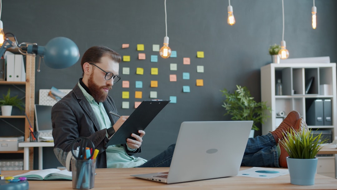 Man working at desk with laptop and notes
