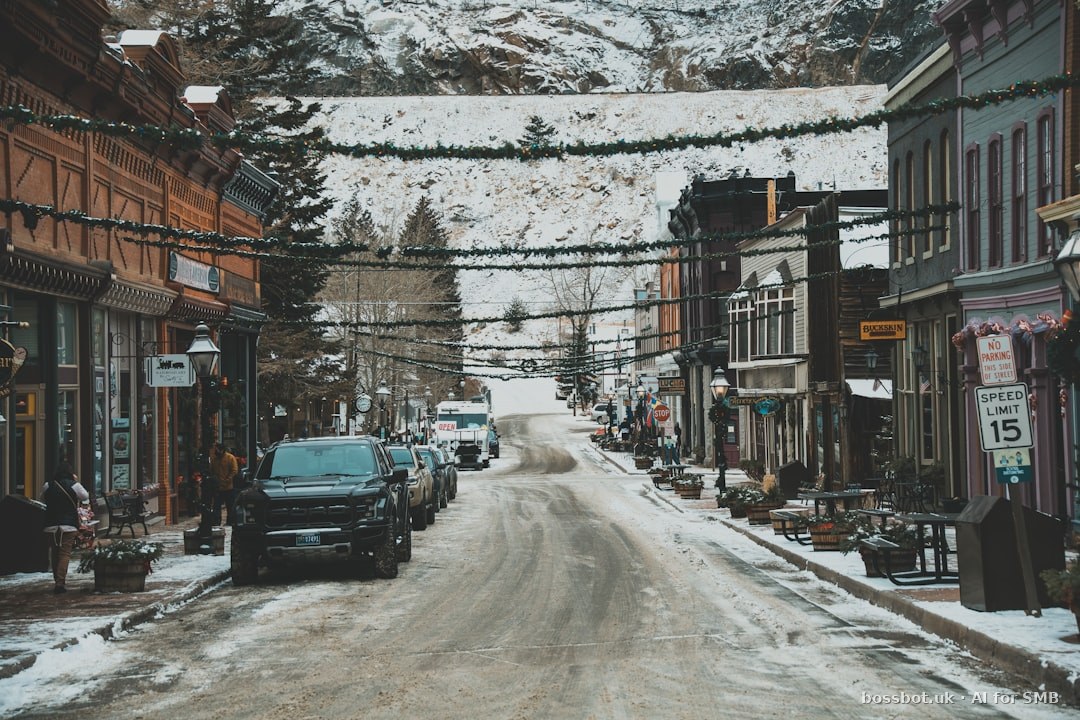 A snowy street with cars parked on the side of it