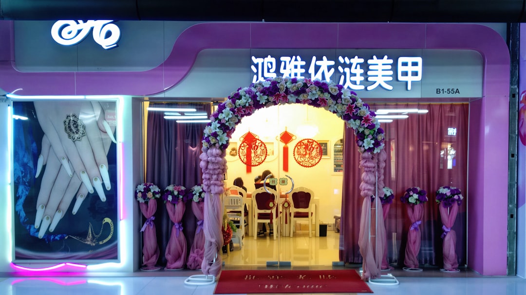 Nail salon entrance decorated with flowers and signage