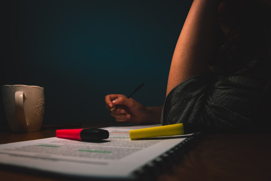 Person holding black pen in front of printed document