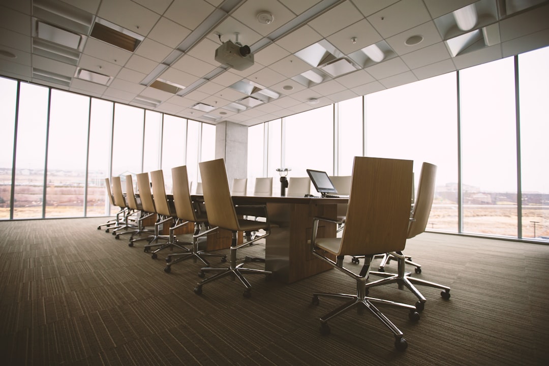Oval brown wooden conference table and chairs inside conference room