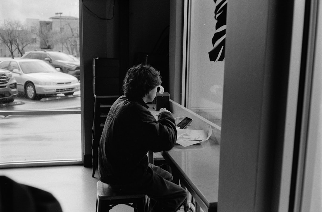 Person sitting at a window drinking coffee