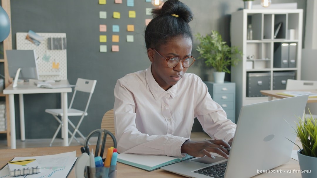 Woman working on a laptop at a desk.