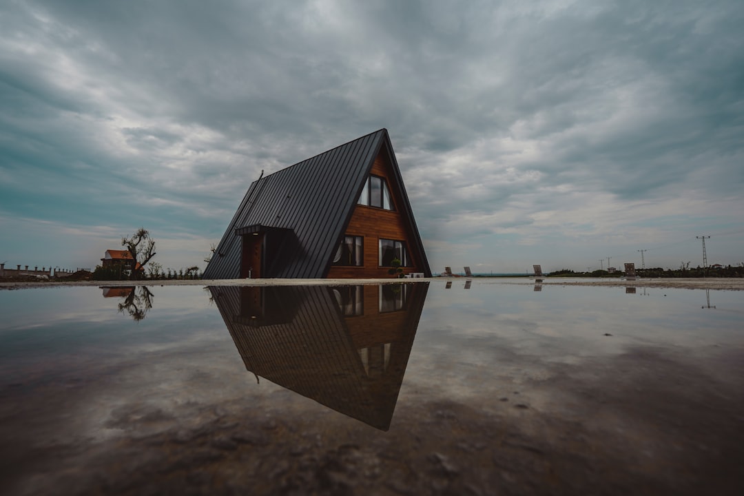 Modern a-frame cabin reflected in still water
