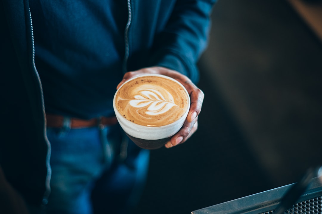 A person holding a cup of coffee in their hand