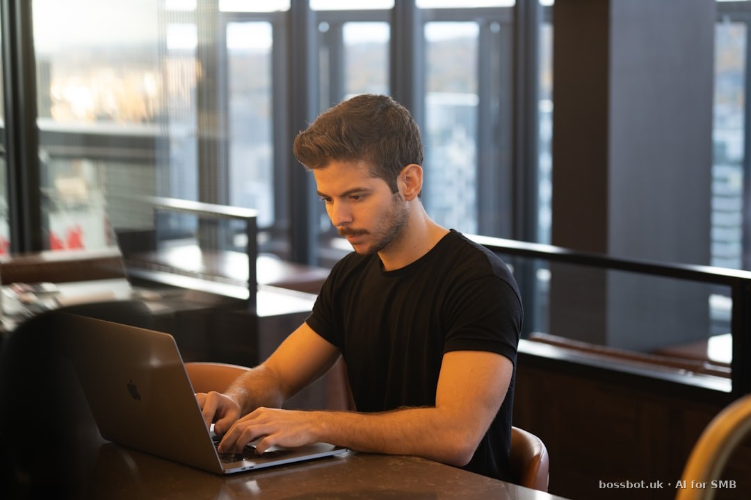 Man in black crew neck t-shirt using macbook