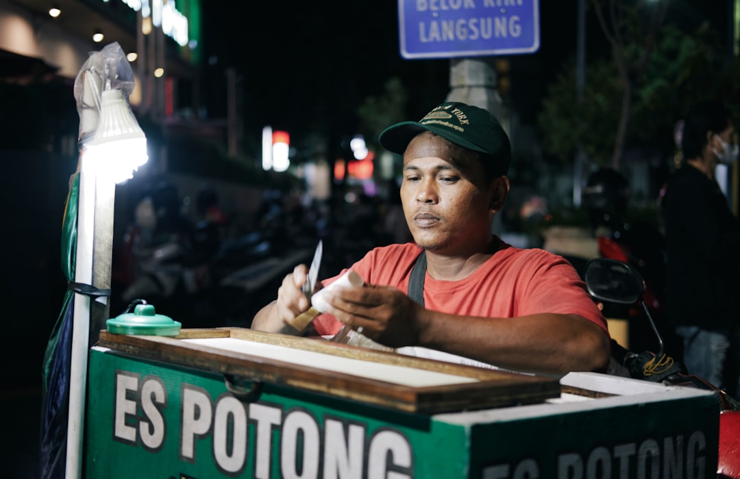 A man sitting at a table writing on a piece of paper