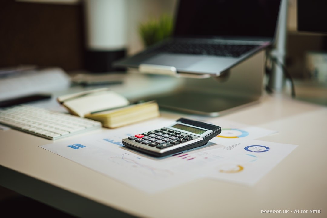 A calculator sitting on top of a table next to a laptop