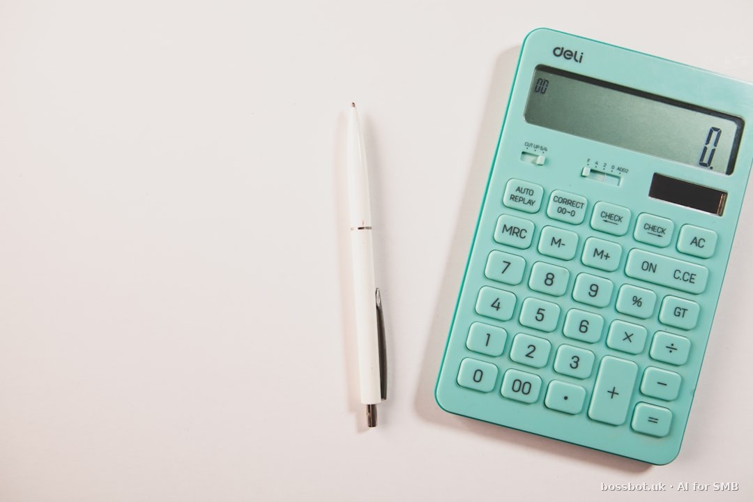 A teal calculator and white pen on a white surface.