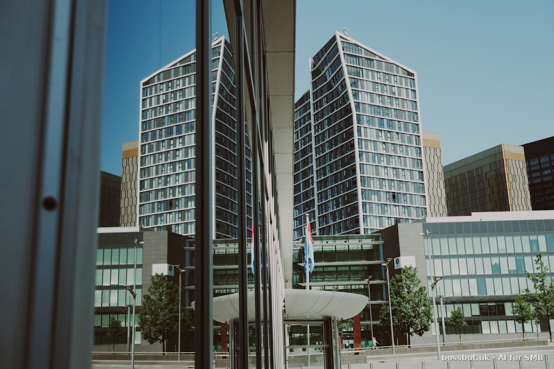 Skyscrapers reflected in a building's glass facade under clear sky.
