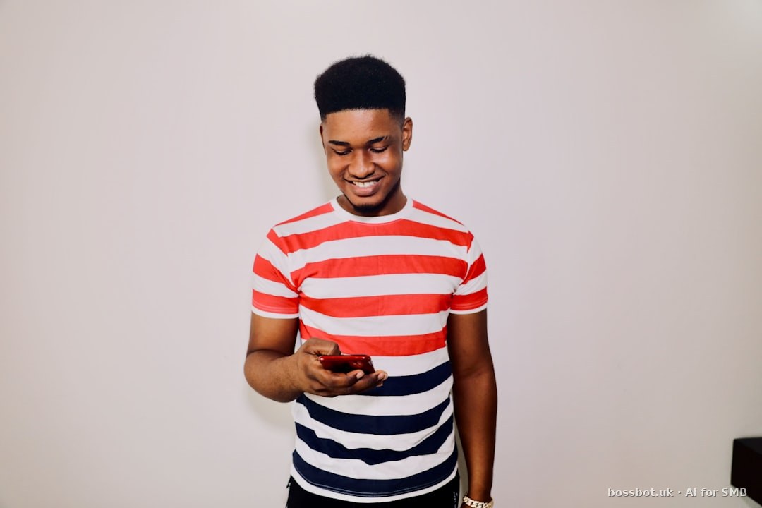 A man in striped shirt holding a cell phone