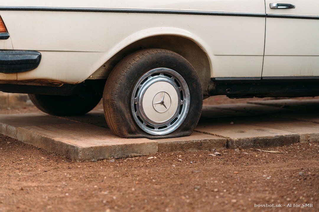 A flat tire on an old white car.