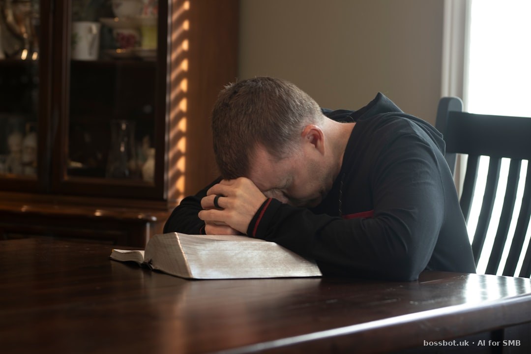 A man sitting at a table with his head in his hands