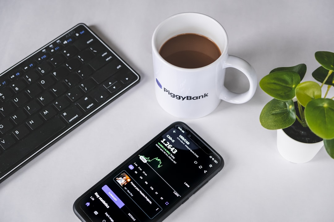A cell phone sitting next to a cup of coffee