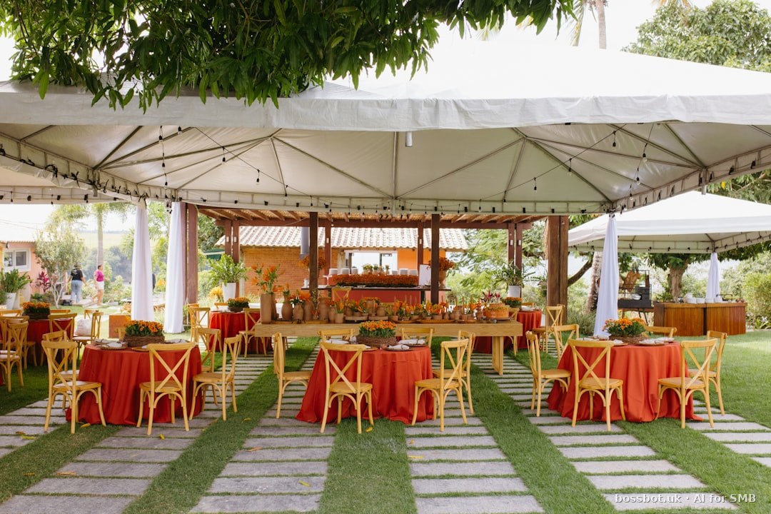 Outdoor event under white tents with red tables and chairs