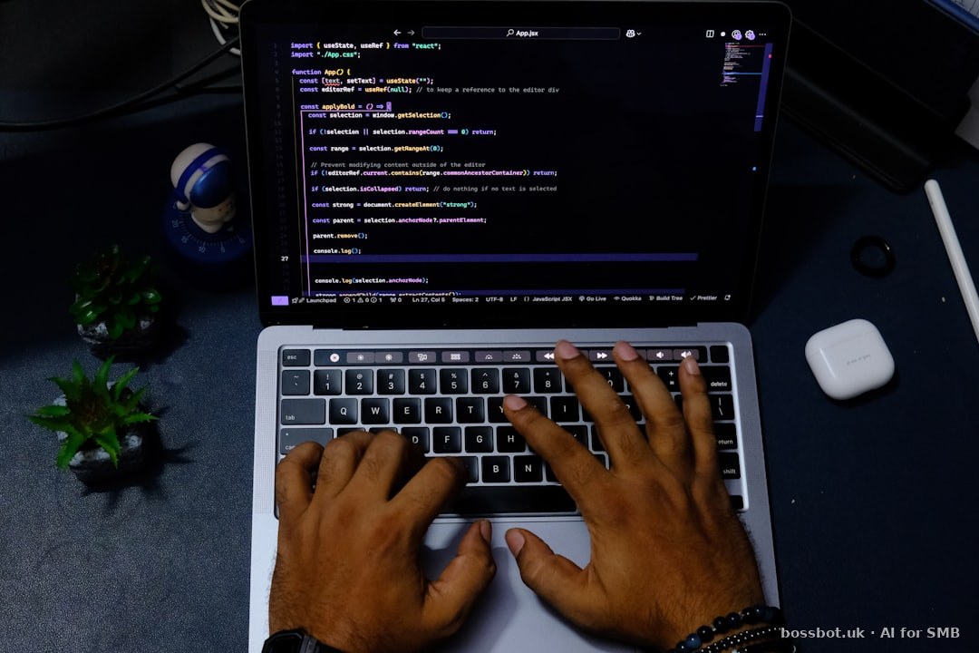 Hands typing code on a laptop computer.