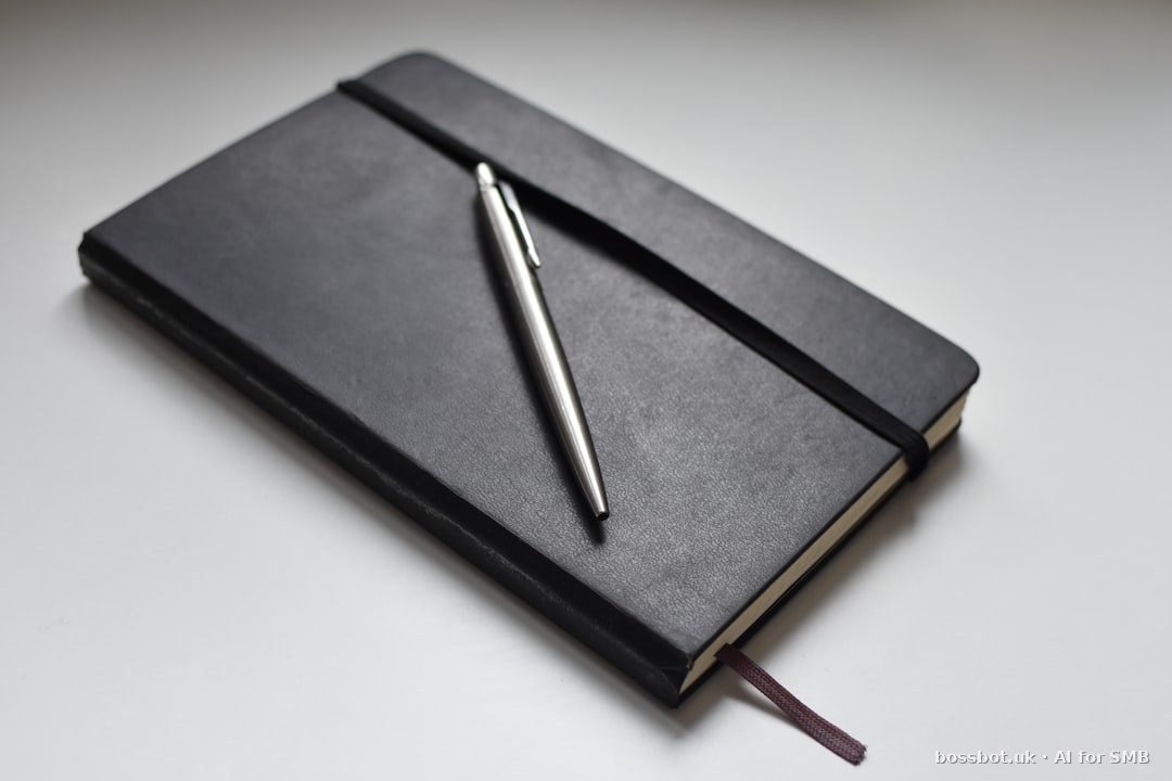 Silver click pen on black book