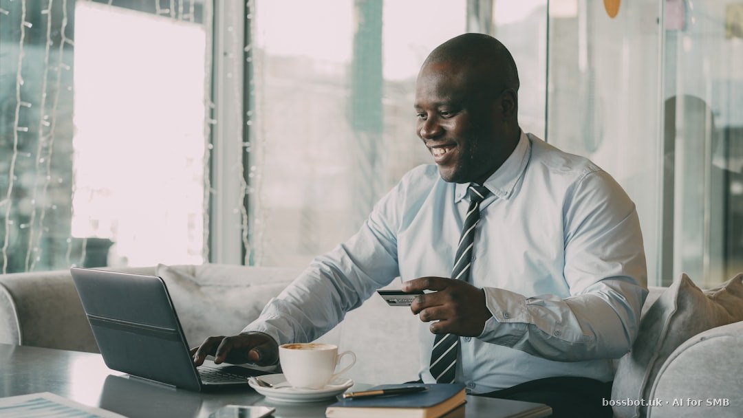 Man with credit card using laptop with coffee.