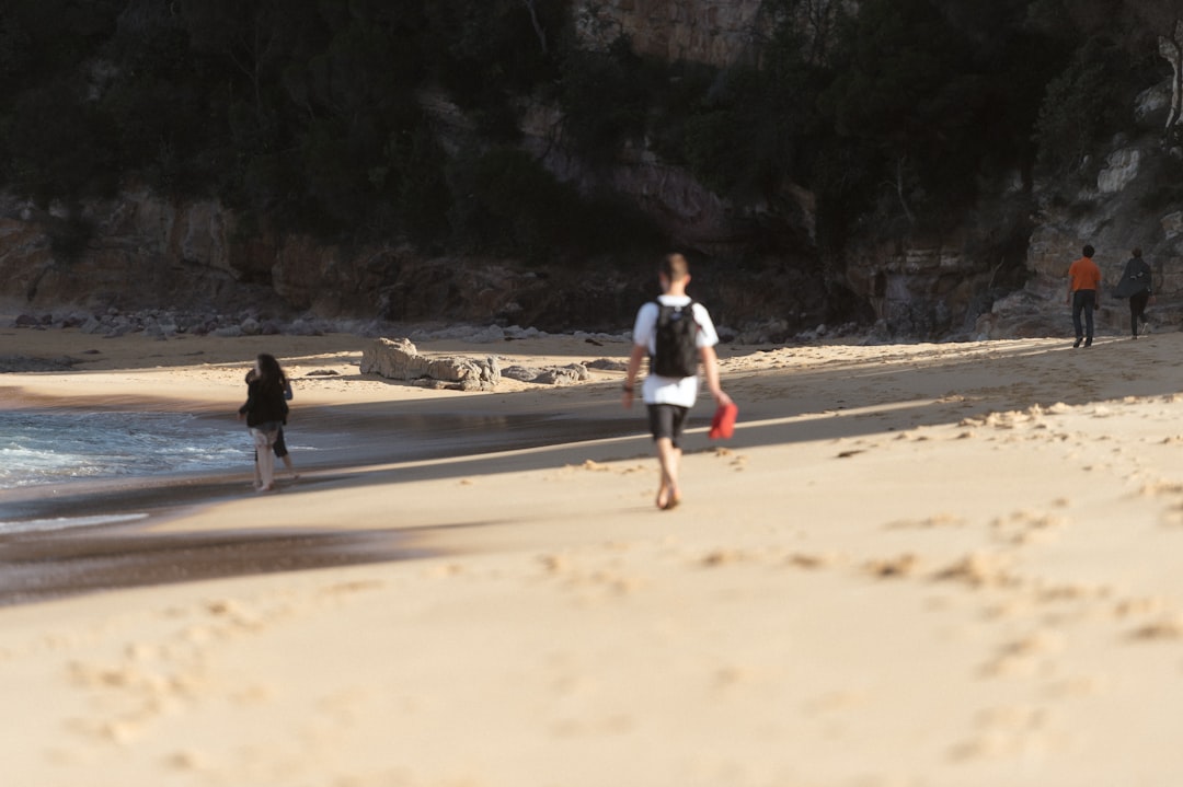 A man is running on the beach with a frisbee