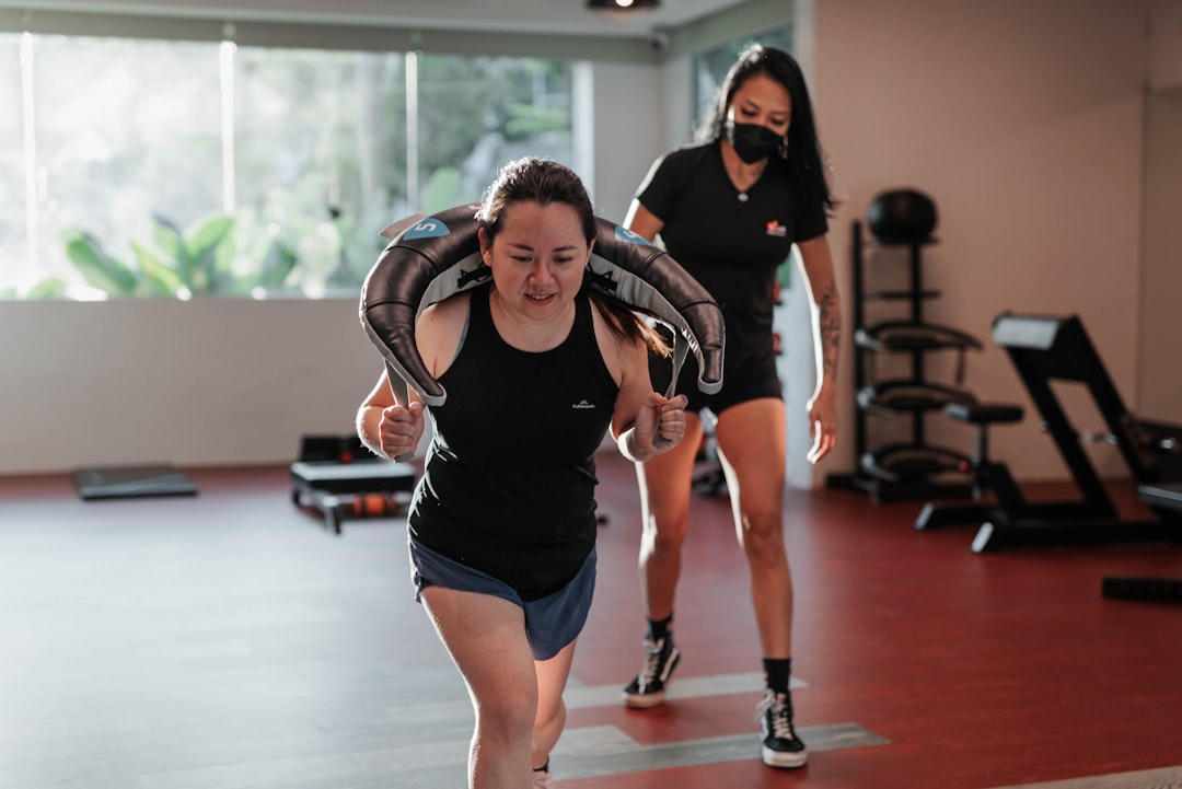 Woman lunging with weight while trainer supervises
