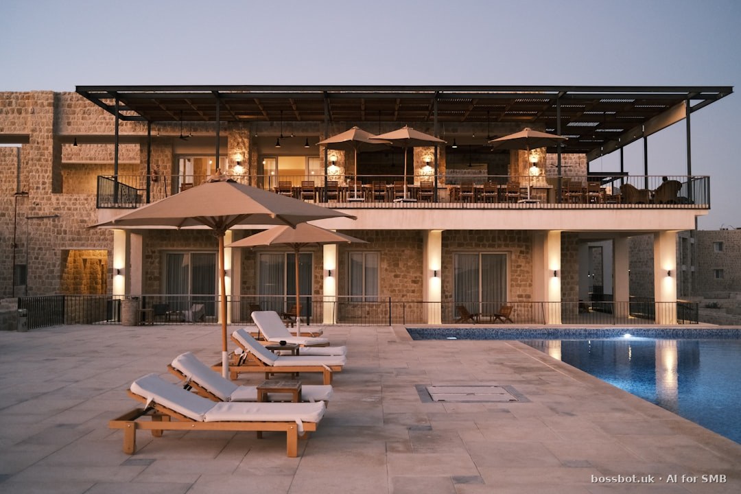 Two lounge chairs and an umbrella near a swimming pool