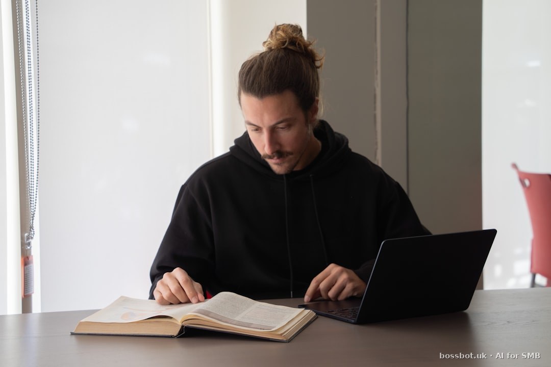 Student studying at desk with books and laptop