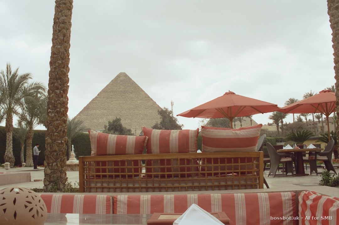 Outdoor terrace with striped furniture facing pyramid