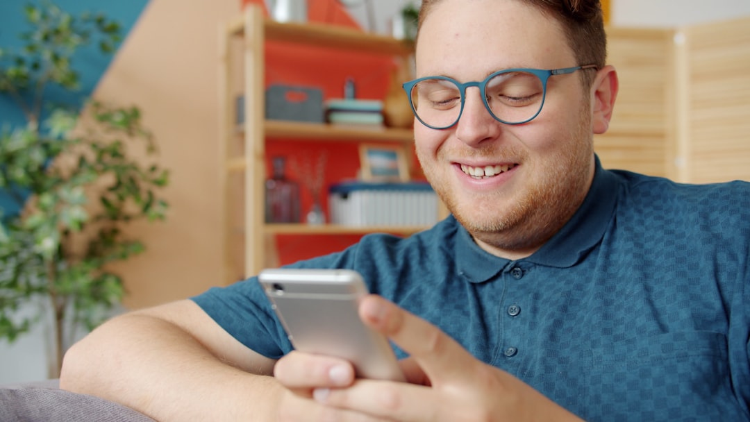 Man smiling while looking at his phone